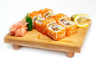 orange and white sushi on brown wooden tray